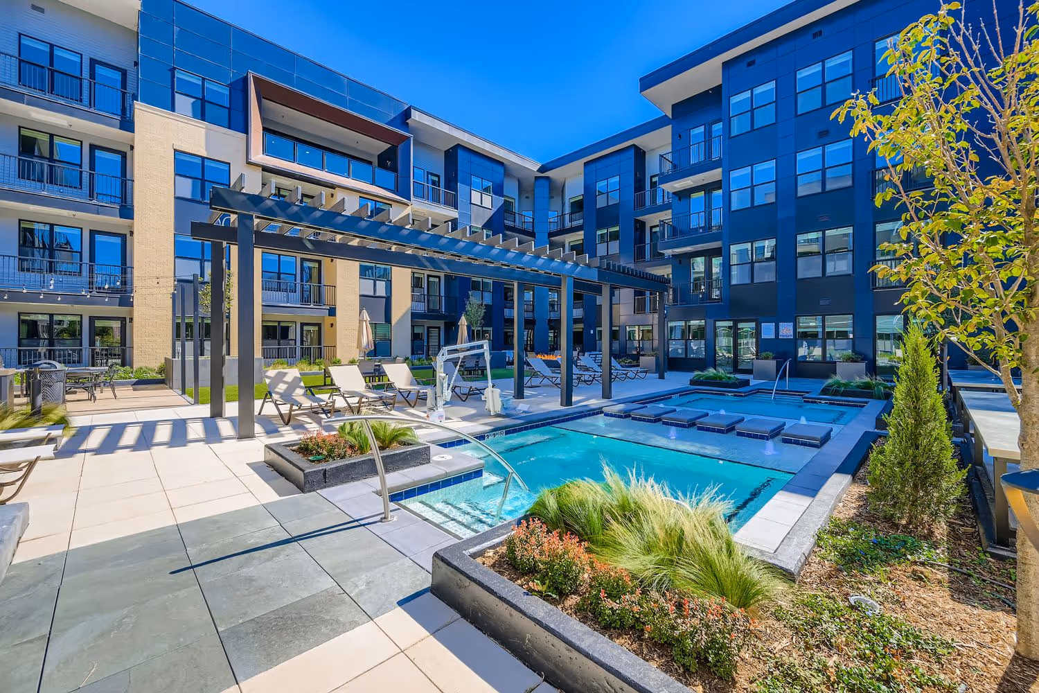 Resort-style courtyard pool deck with integrated hot tubs at Avian Apartments in Colorado Springs.