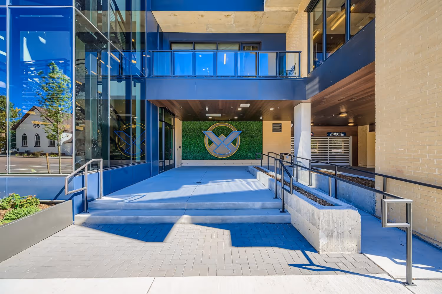 Modern apartment building entrance with the Avian logo against a green wall in Colorado Springs.
