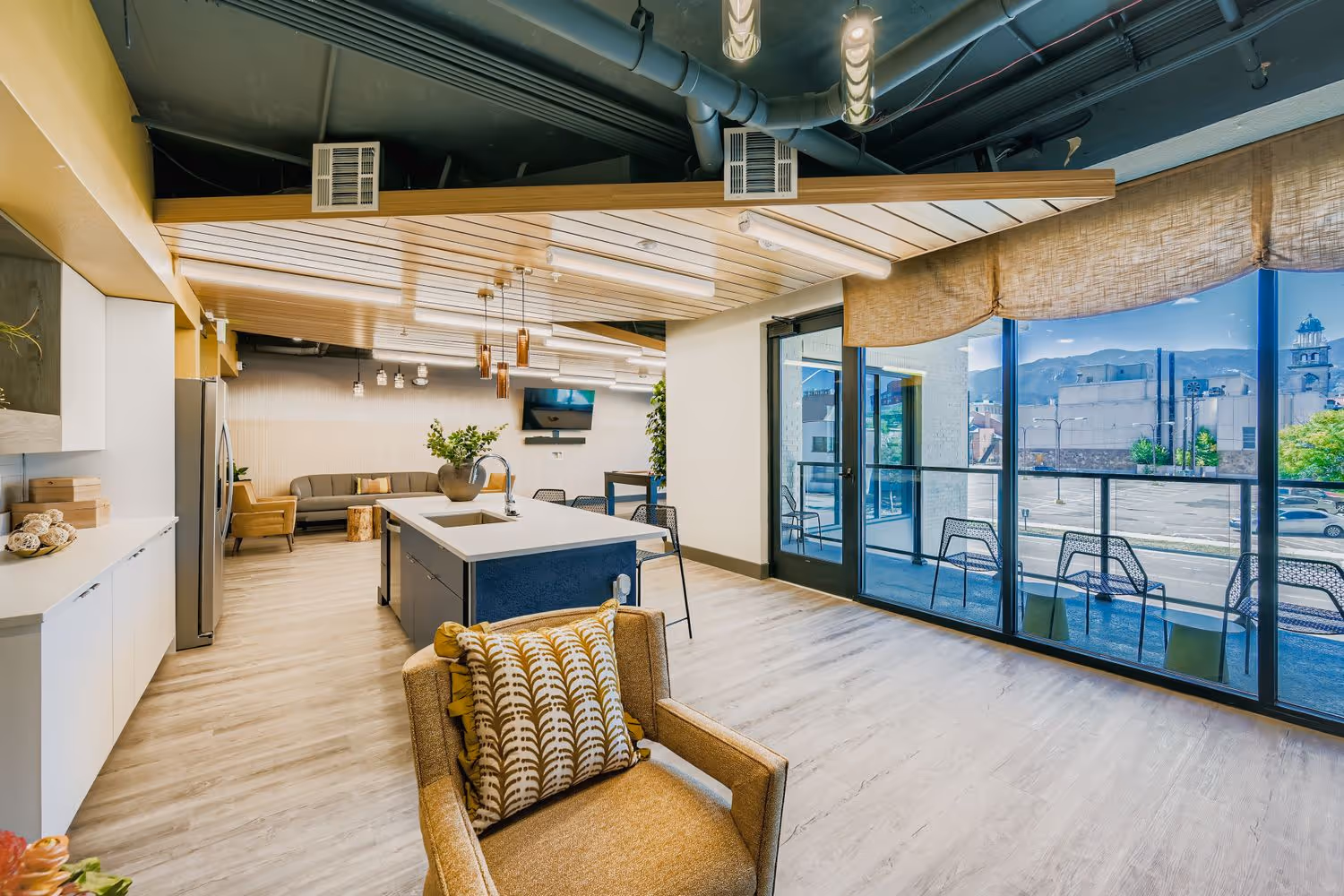 Community kitchen with a large island and pendant lighting inside the Avian Apartments clubhouse.