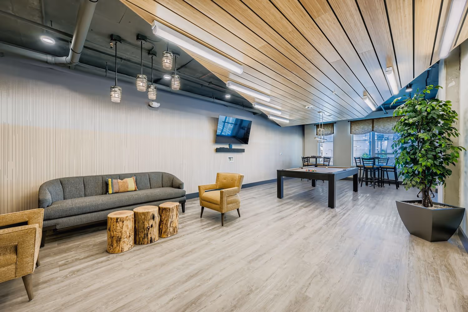 Resident game room with a billiards table and modular seating at Avian Apartments.